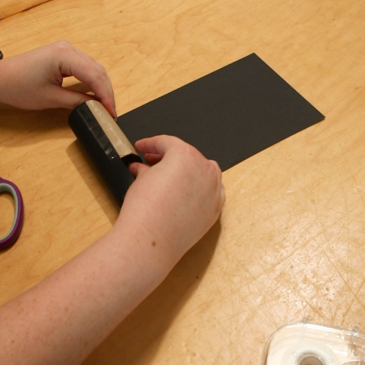 Wrapped paper towel roll in black paper.